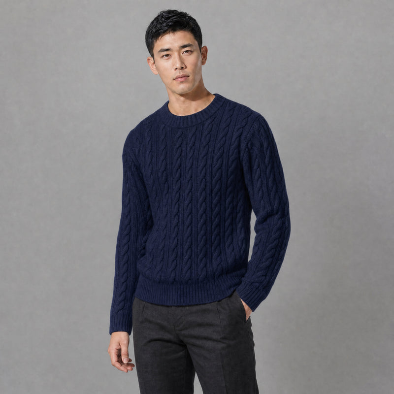 The Cartographer Men's Cable-Knit Crewneck Sweater in Navy Blue, worn by model