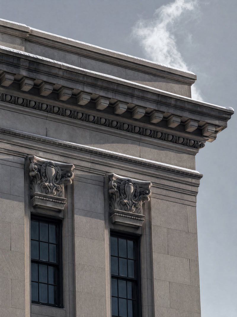 Snow settled along a limestone cornice in hard side light