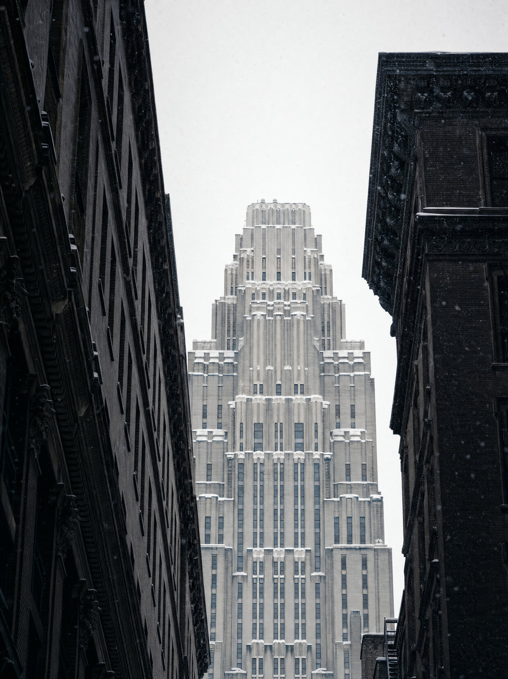 The crown of an art deco tower seen from the street against a winter sky